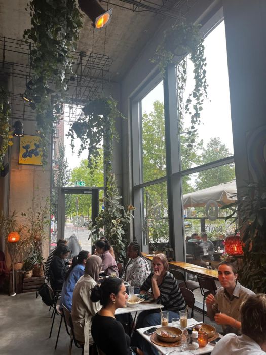 In a cafe called Benji’s in Wibautstraat. The nice, tree-framed street is visible out of the window nicely complementing the greenery of the insides.
