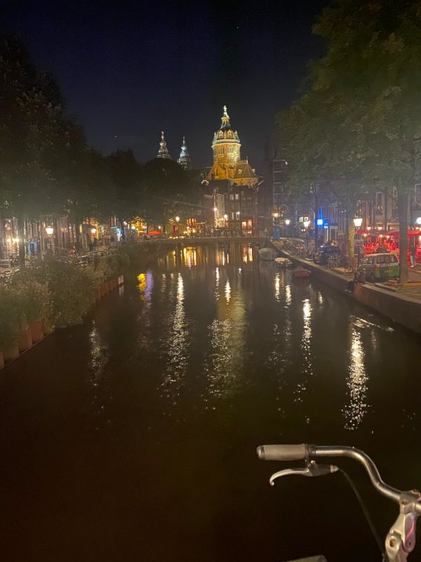 A photo of a canal in the centre of Amsterdam as we head toward the red light district (visible on the right). At night, the red light district is absolutely filled with tourists.