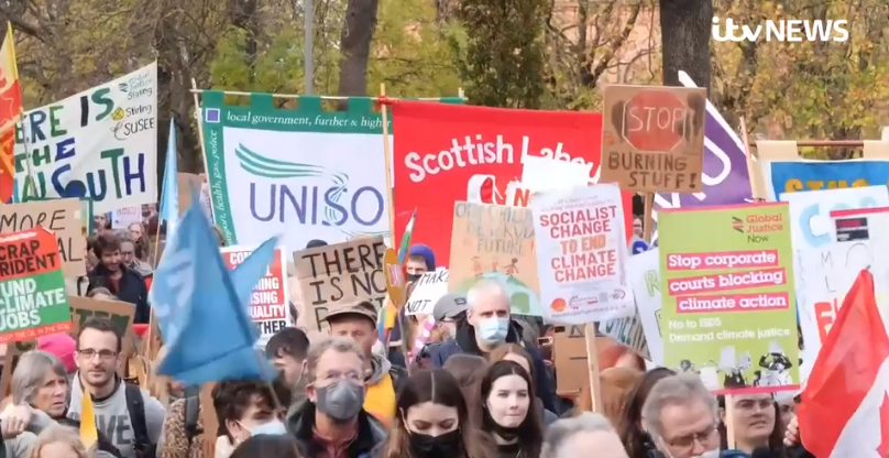 Try to spot how many political affiliations there are. Notable mentions "Socialist change" being wielded by a child; and "Scottish Labour" wielded prominently.
