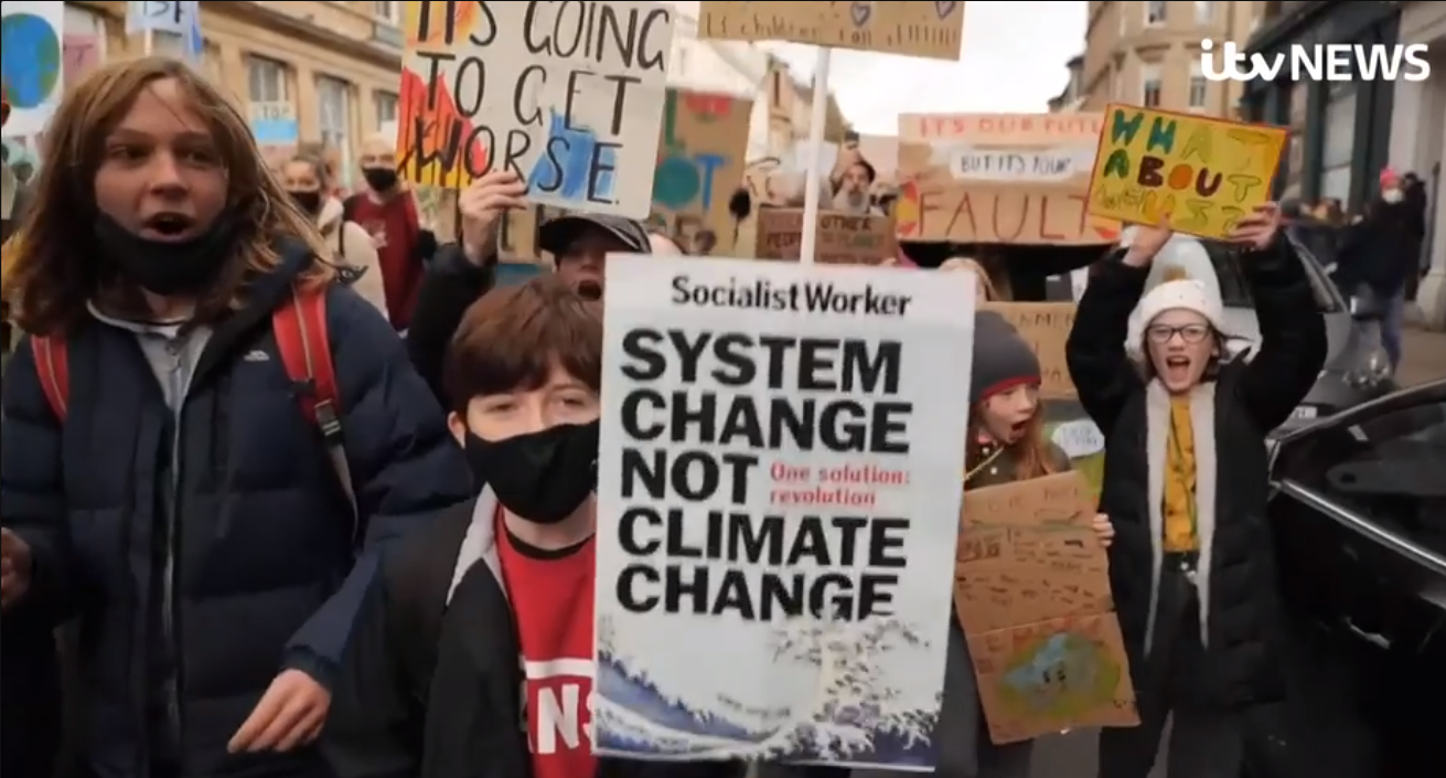 A CHILD wielding a sign from the Socialist Workers’ Party which reads "The Solution: Revolution". To reiterate: A CHILD